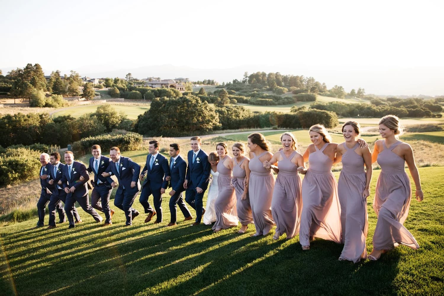 Wedding party celebrating on the green at golden hour at Flying Horse Resort & Club in Colorado Springs, Colorado