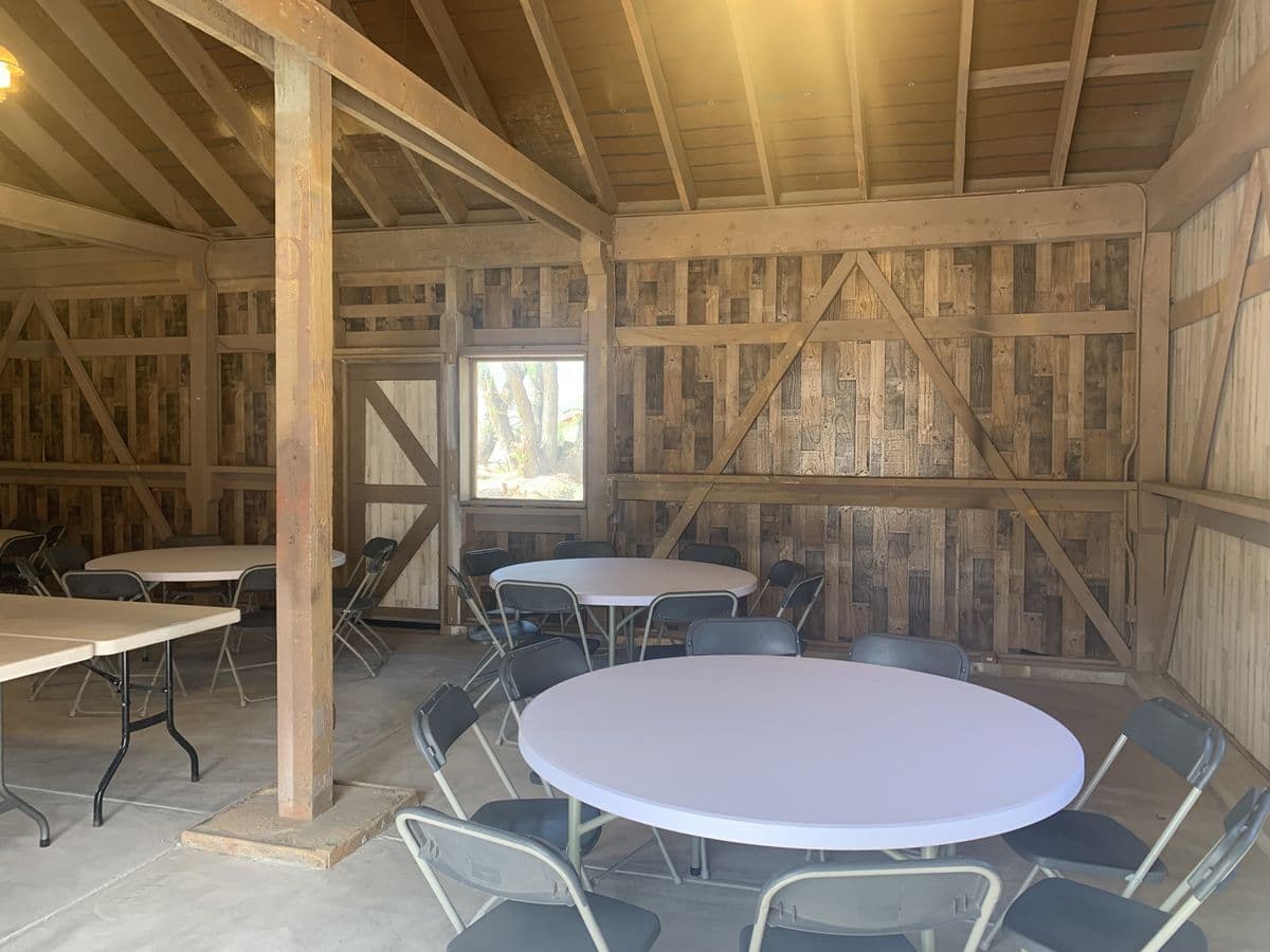Rustic interior of the Reynolds Ranch Hay Barn set with round tables for a reception in Monument, Colorado