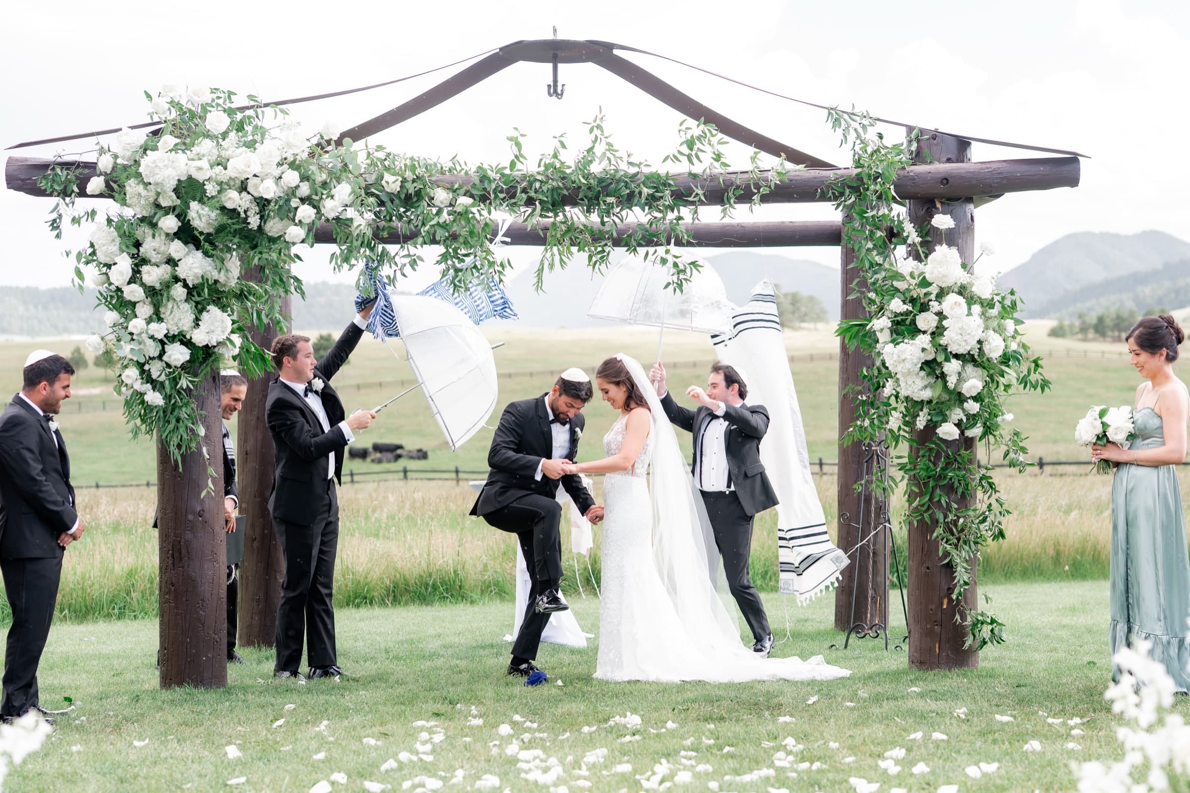 Outdoor wedding ceremony under a wooden arch with mountain meadow views at Spruce Mountain Ranch in Larkspur, Colorado