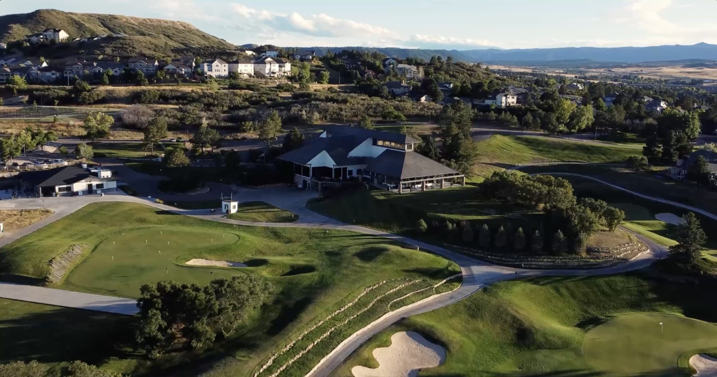 Aerial view of the clubhouse and rolling golf greens at The Oaks at Plum Creek in Castle Rock, Colorado